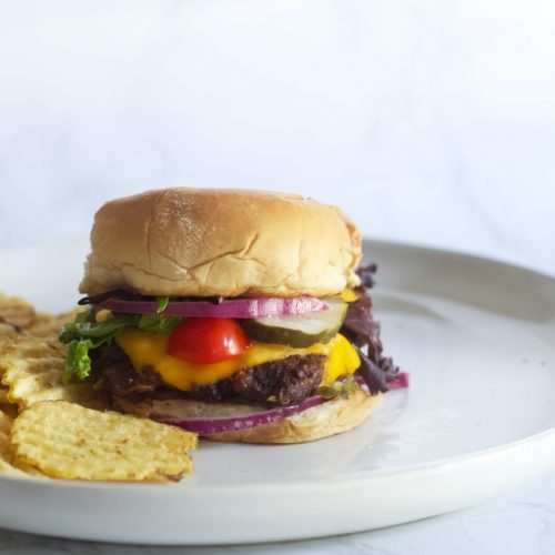 juicy burger with light fluffy buns and tomatoes, onion, lettuce