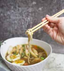 bowl of ramen soup with noodles wrapped around chopsticks