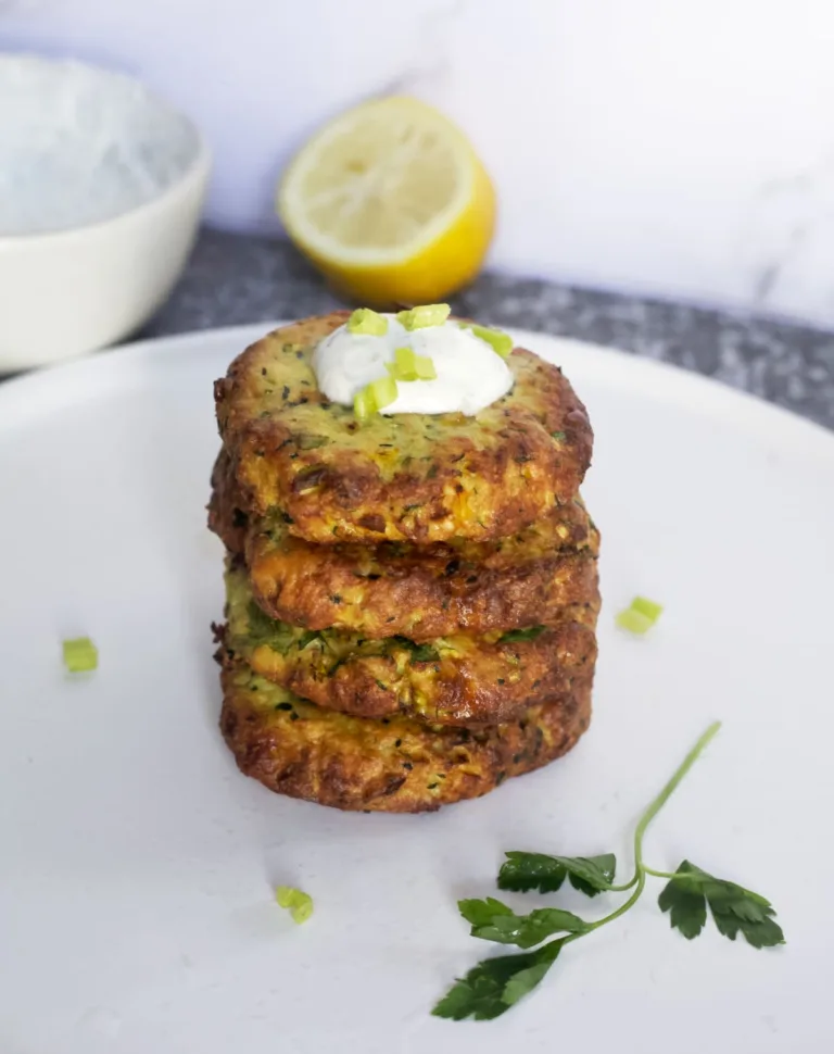 crispy zuchinni fritters stacked with a dollop of yogurt sauce on top